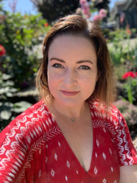 Woman with dark hair sitting in a garden